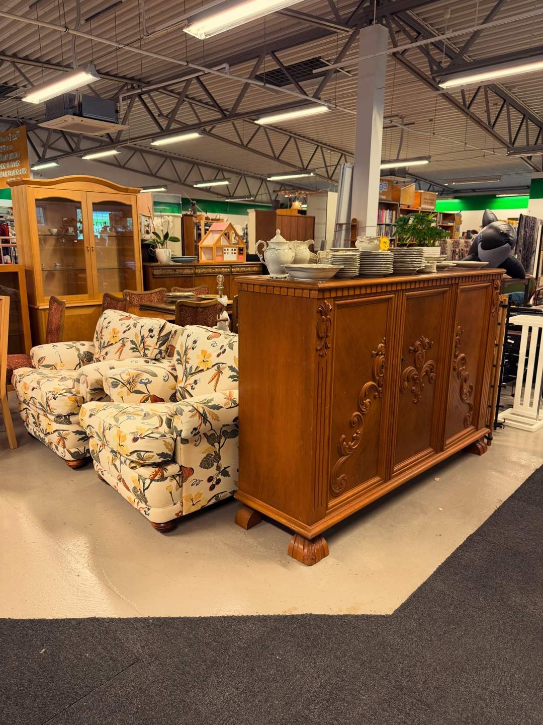 Vitrinskåp, skänk och fåtöljer i Framtids second hand-butik